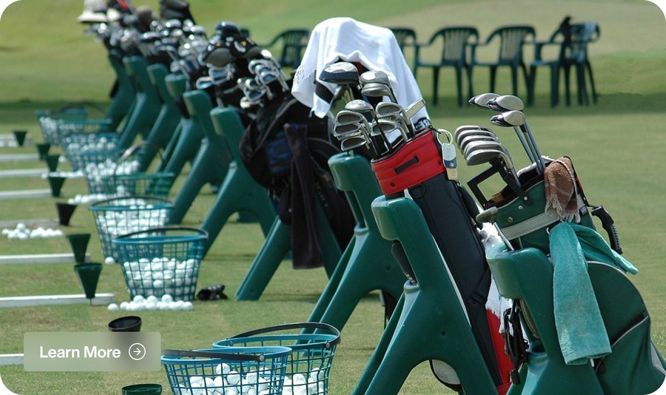 A row of golf bags are lined up on a golf course