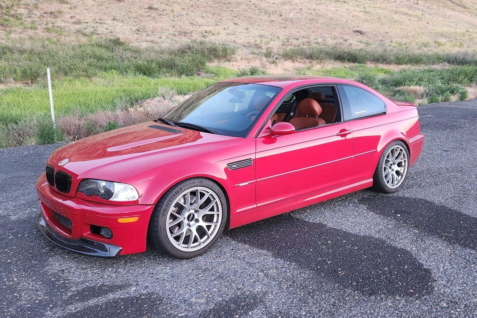 A red bmw m3 is parked on the side of the road | Bavarian Auto Clinic