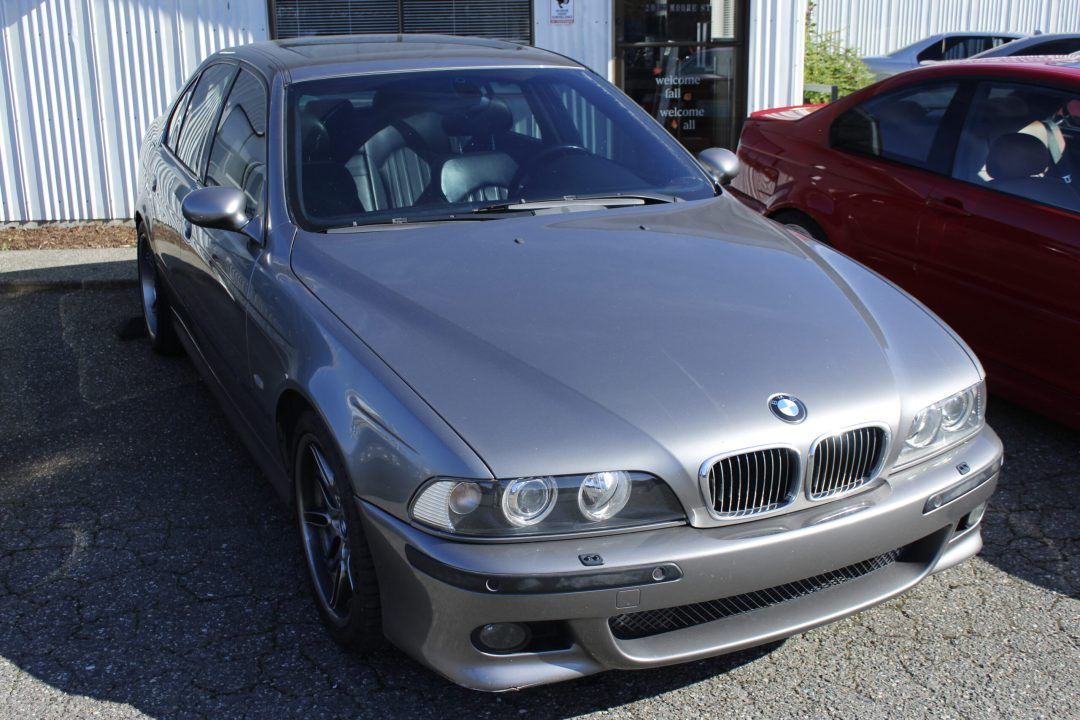 A silver bmw is parked next to a red car | Bavarian Auto Clinic
