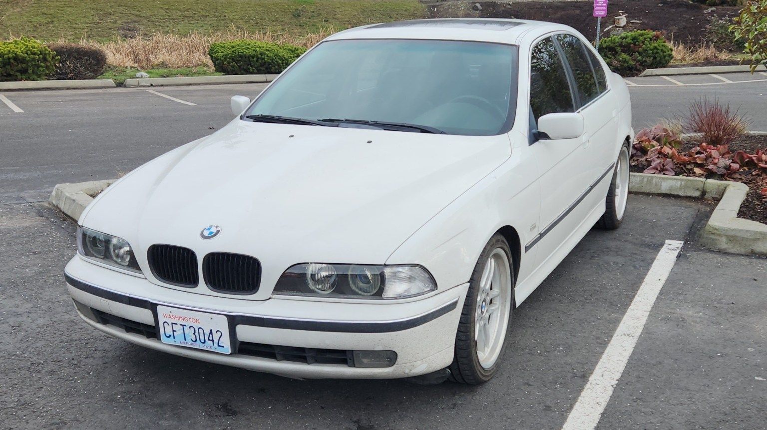 A white bmw is parked in a parking lot. | Bavarian Auto Clinic