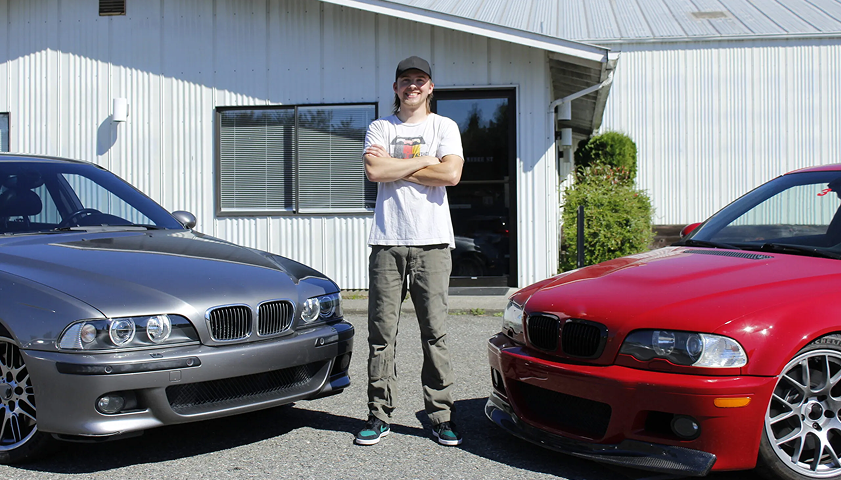 A man is standing in front of two bmw cars | Bavarian Auto Clinic