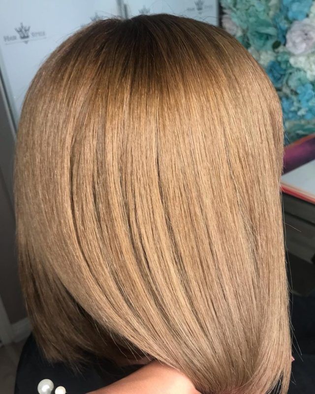 Blonde, straight bob hairstyle with darker roots.