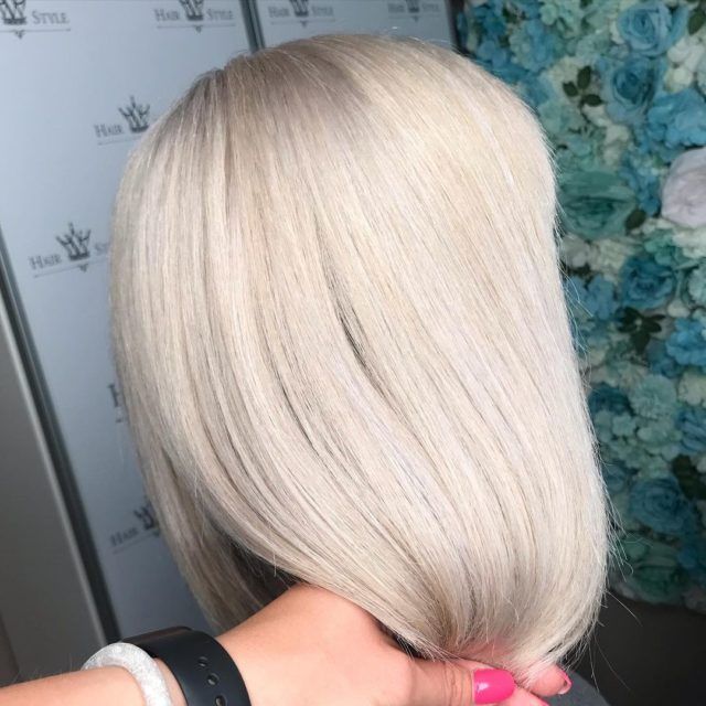 Close-up of a person's light blonde, angled bob hairstyle.
