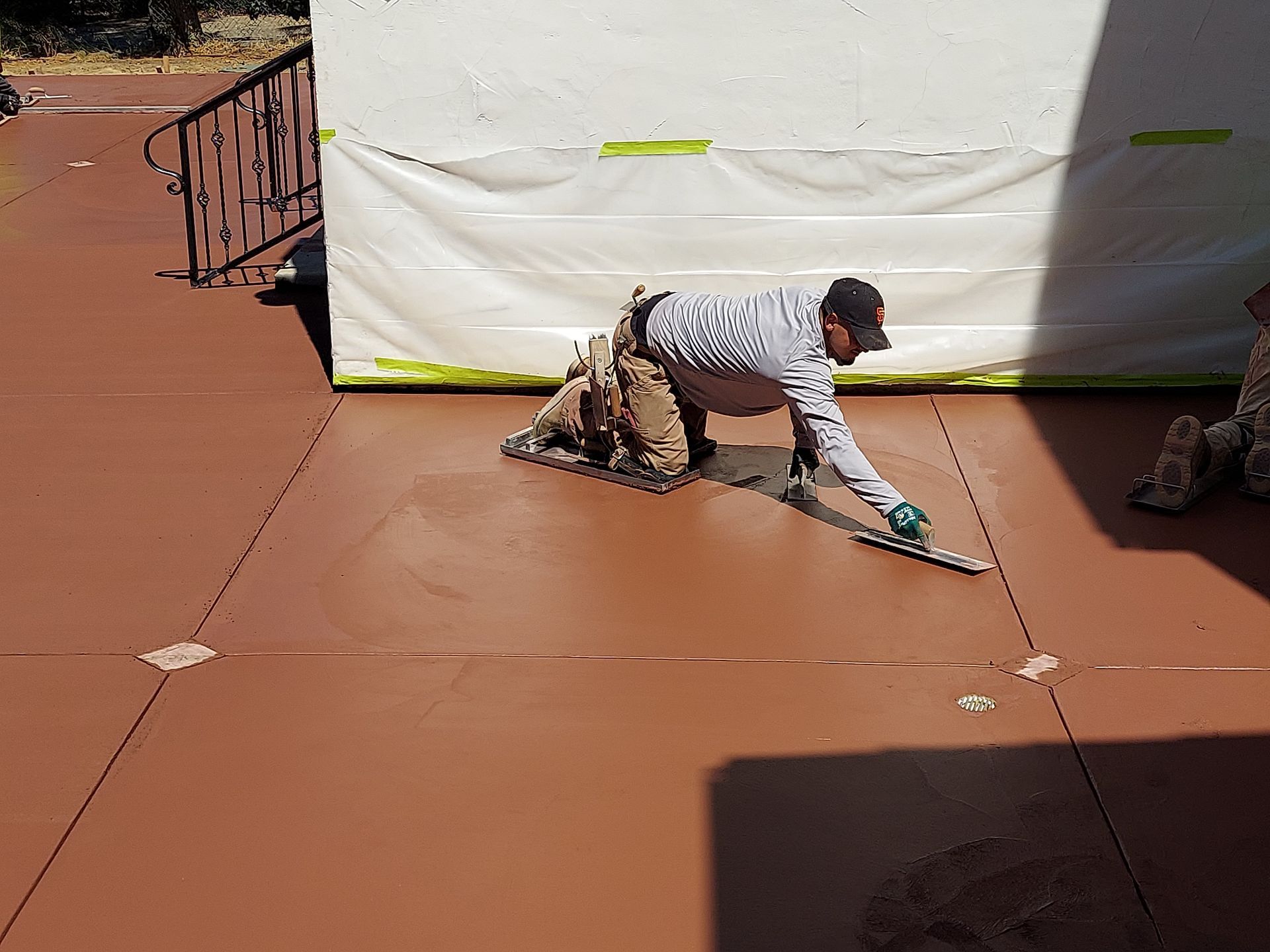 Concrete pour at a construction site; workers guide a concrete pump truck boom over forms.