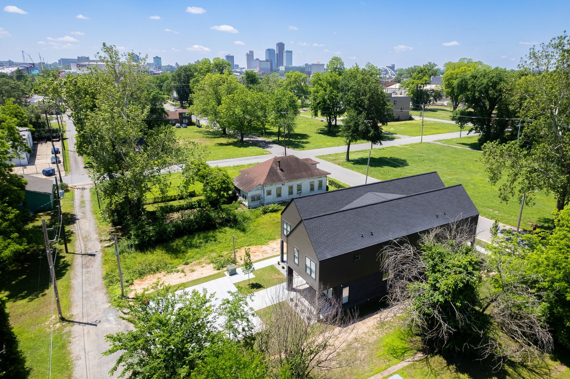 An aerial view of a house in a residential area with a city in the background.