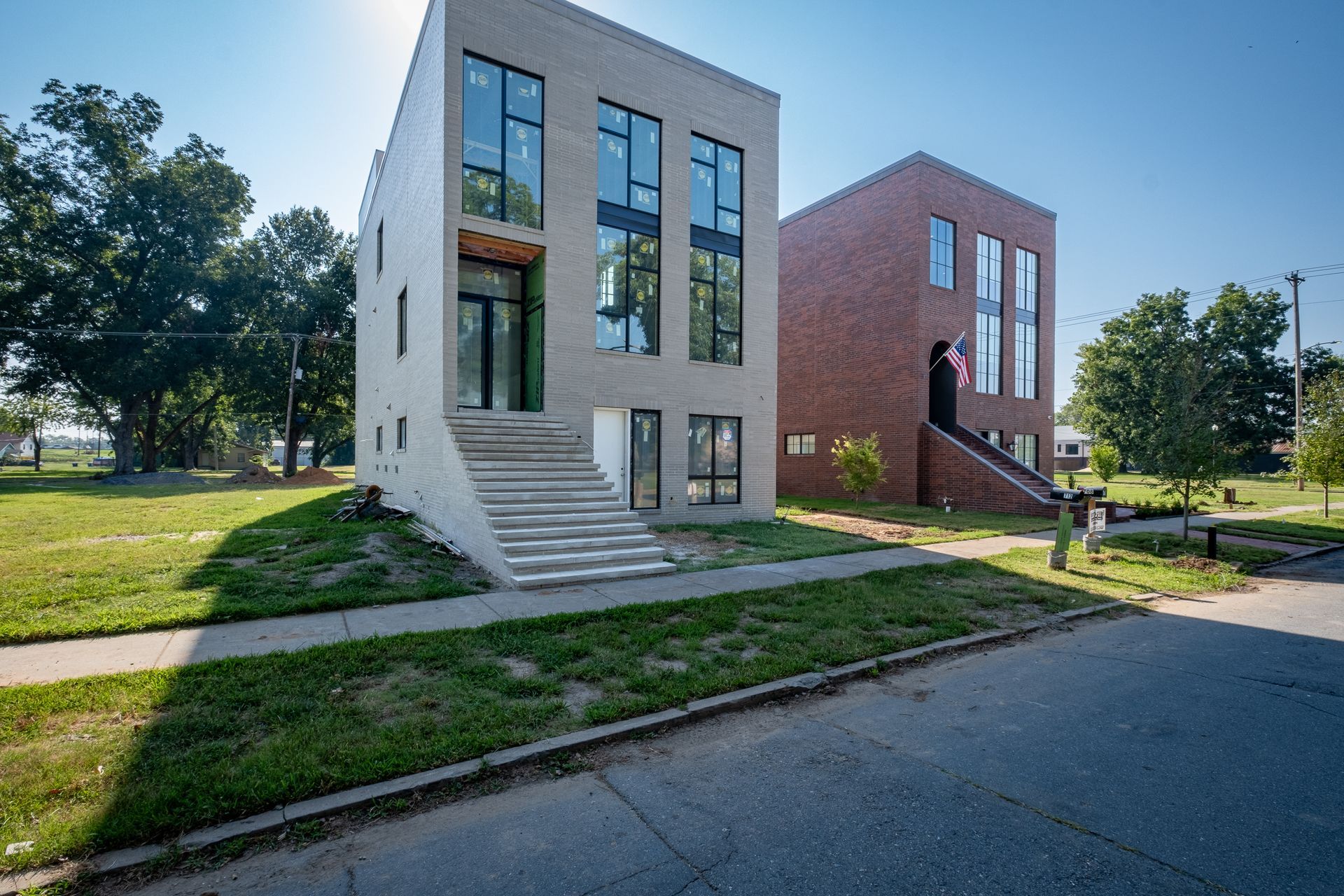 A brick building and a white building are next to each other on a sunny day.