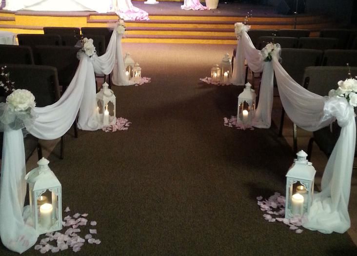 A wedding aisle decorated with white lanterns and flowers