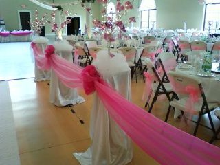 A room filled with tables and chairs decorated in pink and white