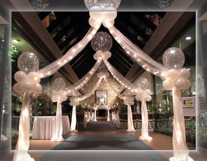 A hallway decorated with white balloons and lights