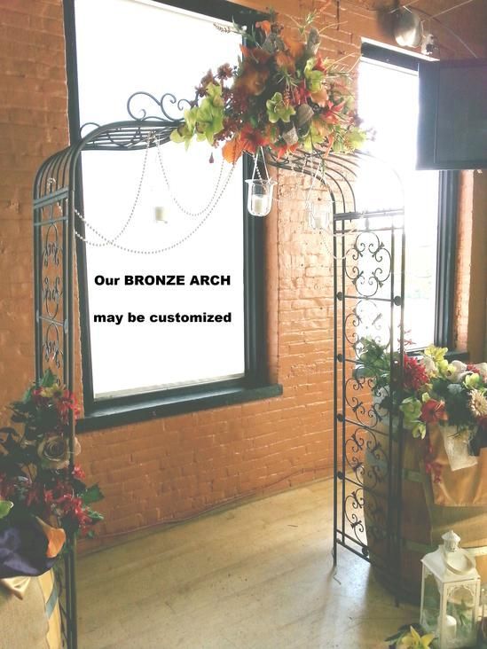 A picture of a bronze arch with flowers hanging from it