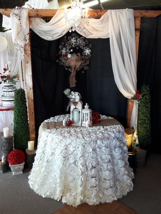 A table with a white table cloth and candles on it