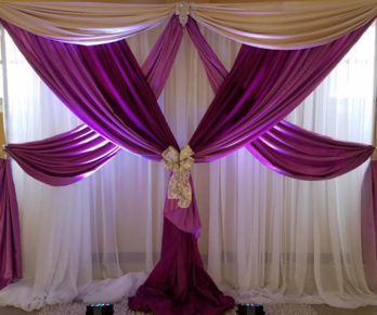 A purple and white curtain is hanging on a wall.