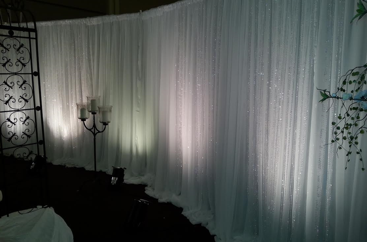 A room with a white curtain and candles in front of it.