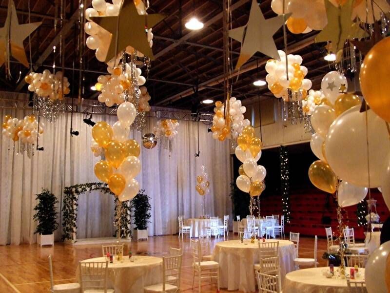 A room decorated with gold and white balloons and stars