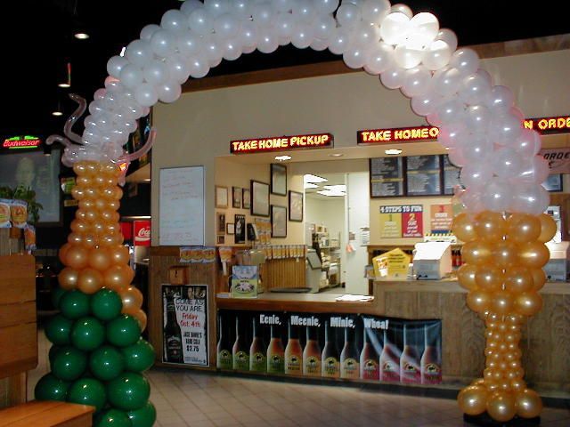 A restaurant with balloons and a sign that says take home pickup