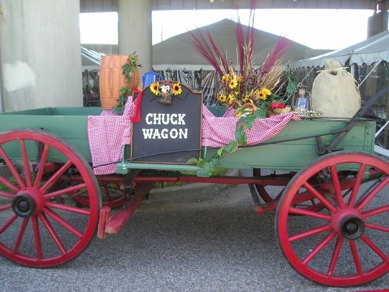 A green wagon with red wheels and a sign that says chuck wagon