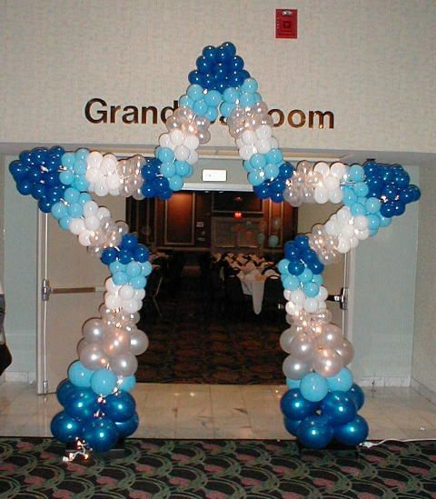 A star made of blue and white balloons in front of a sign that says grand room