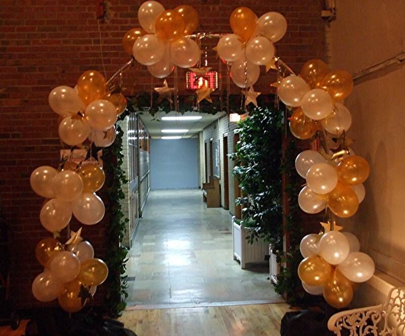A hallway decorated with balloons and a red exit sign