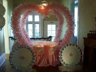 A carriage made out of pink balloons in a hallway