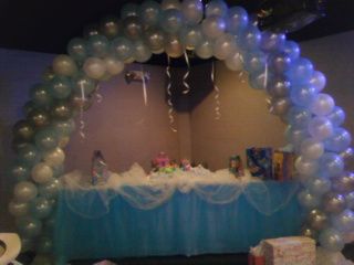 A table with a blue tablecloth and balloons around it