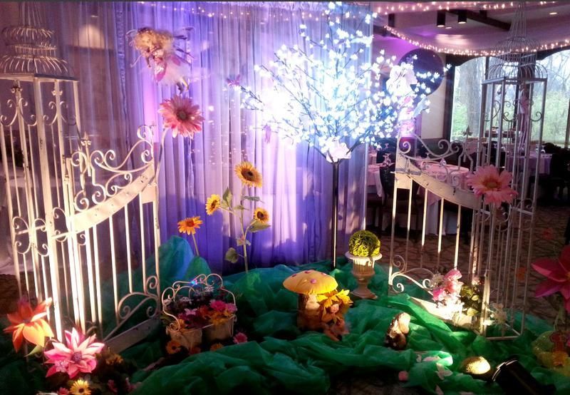 A room decorated with flowers and lights for a party.