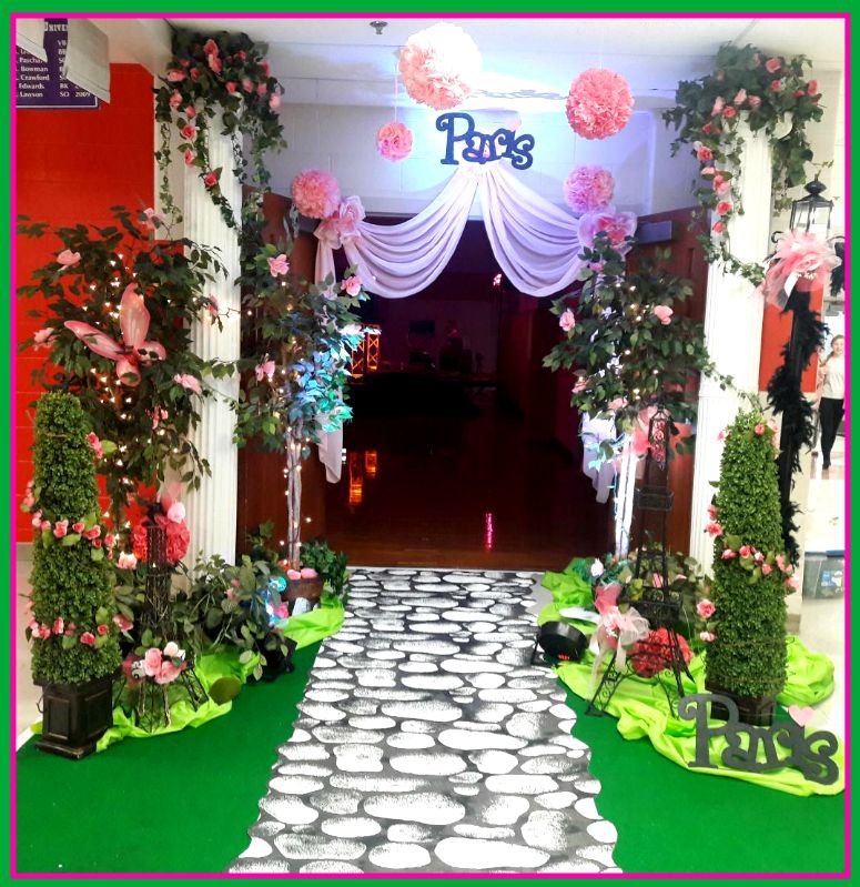 A stone walkway with flowers and a sign that says pacs