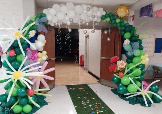 A hallway is decorated with balloons and flowers