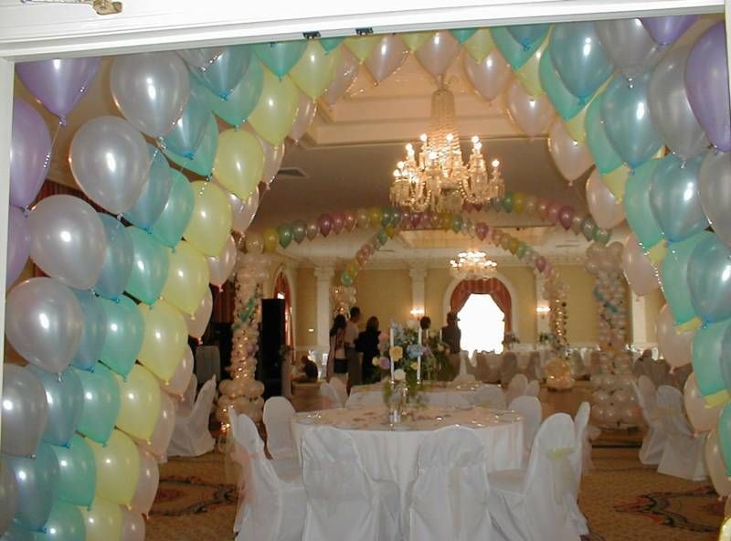 A room with tables and chairs decorated with balloons and a chandelier