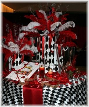 A table decorated with red and white feathers and candles