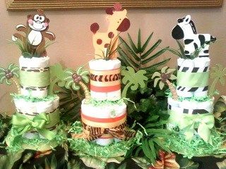 Three diaper cakes with animals on them are sitting on a table