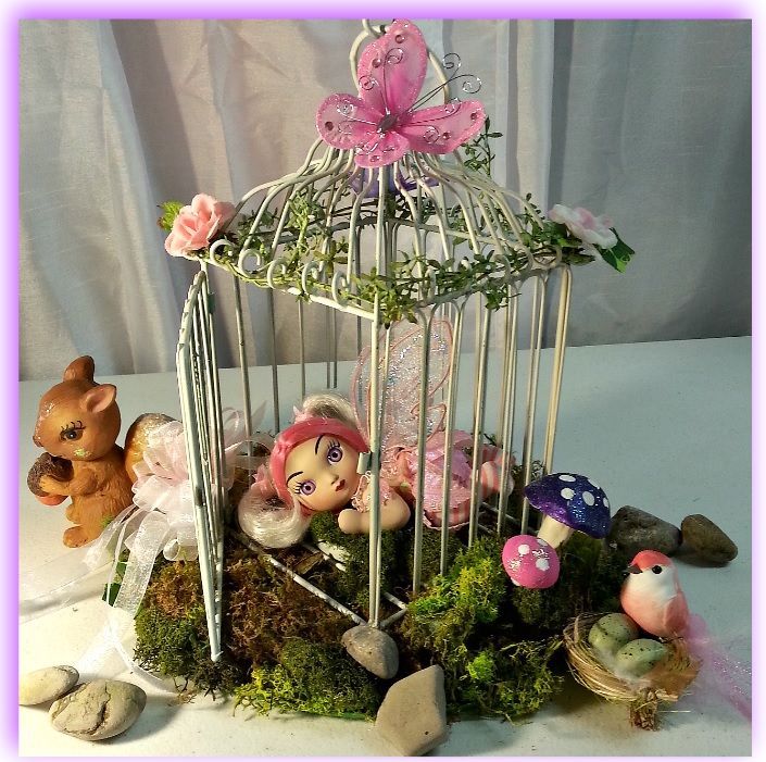 A bird cage with a fairy inside of it