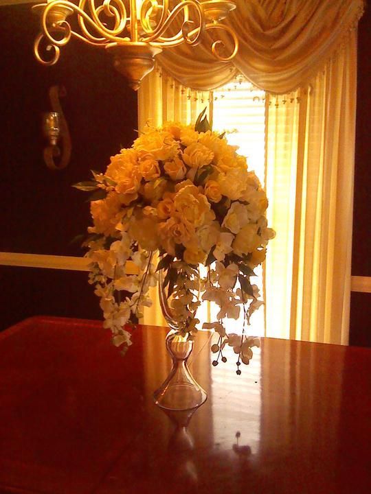 A vase filled with yellow flowers sits on a table