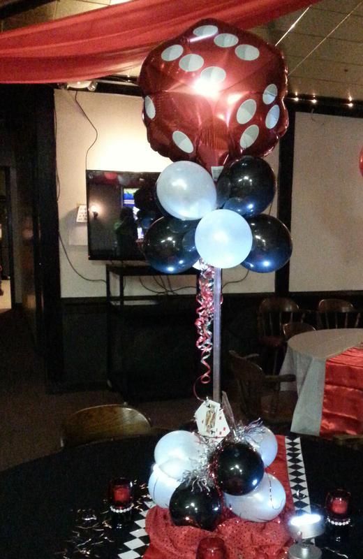 A red dice shaped balloon is surrounded by black and white balloons