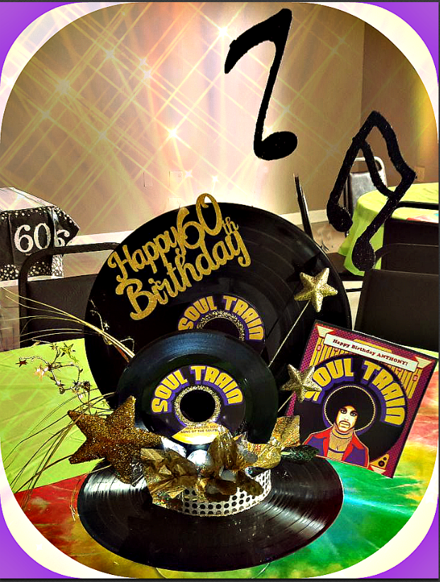 A happy 60th birthday sign is sitting on top of a record.