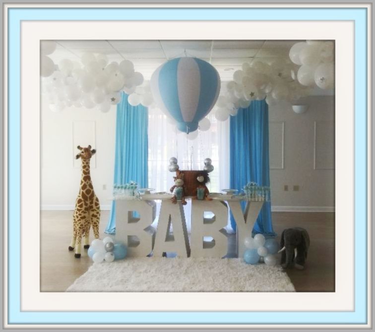 A picture of a baby shower with balloons and a giraffe