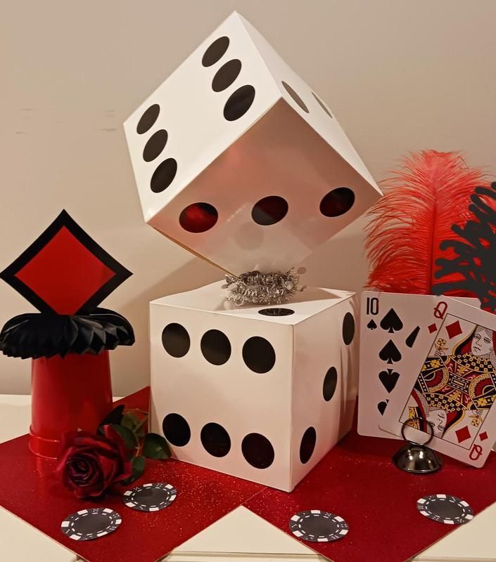 A pair of dice sitting on top of each other next to a queen of spades card