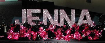 A sign that says jenna is surrounded by pink flowers