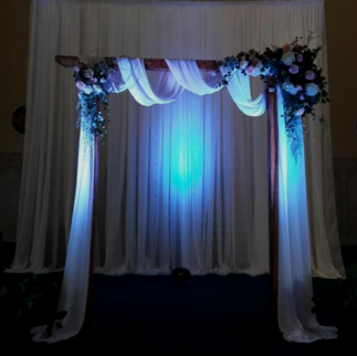 A wedding arch with blue lights behind it