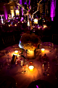 A table with a vase of flowers and candles on it