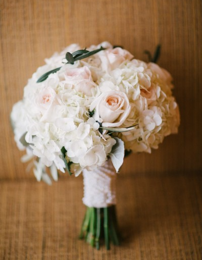 A bouquet of white flowers is sitting on a couch.