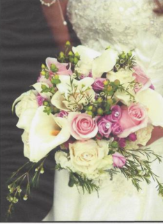 A bride is holding a bouquet of pink and white flowers