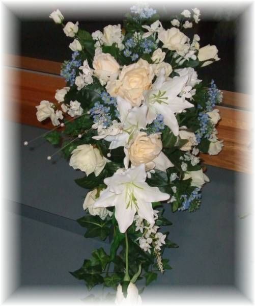 A bouquet of white and blue flowers including lilies and roses