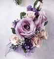 A close up of a bouquet of purple and pink flowers on a table.