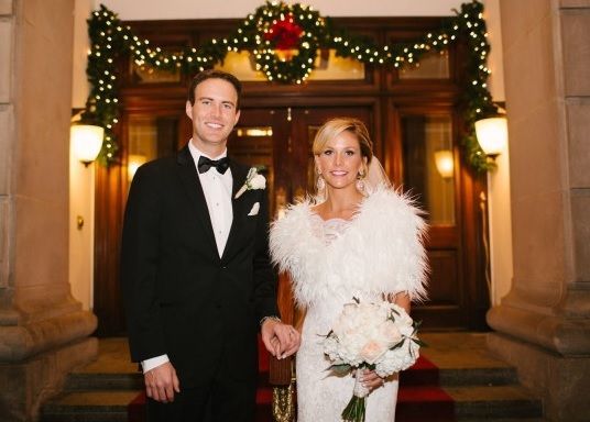 A bride and groom are posing for a picture in front of a building.