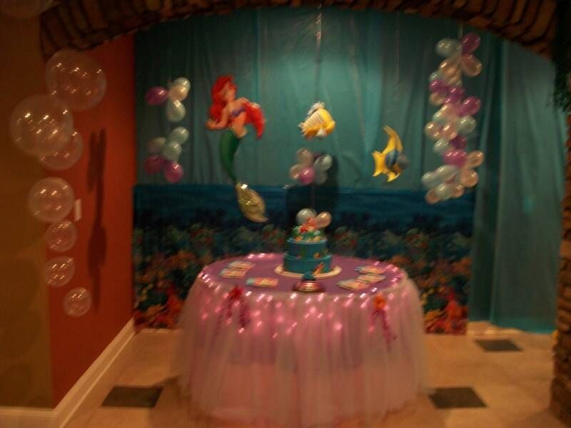 A table with a cake and balloons on it