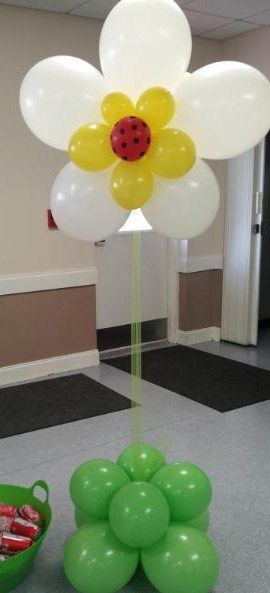 A flower made out of balloons with a ladybug on it.