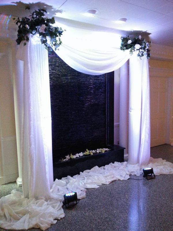 A room decorated with white curtains and flowers