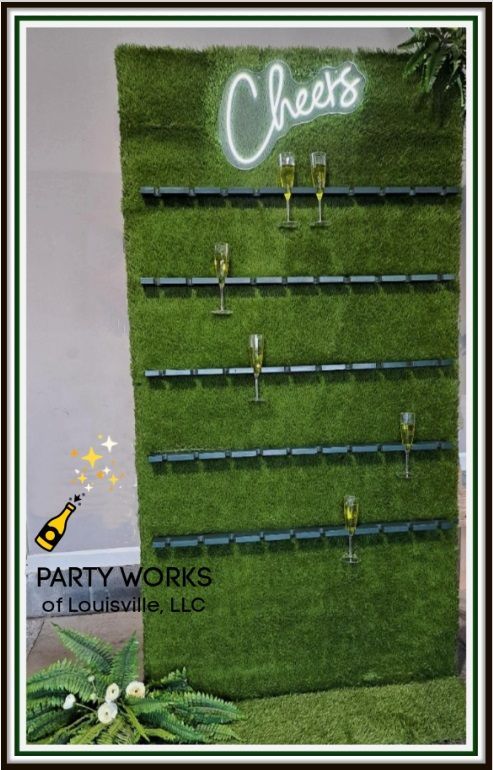 A green wall with a neon sign that says cheers on it.