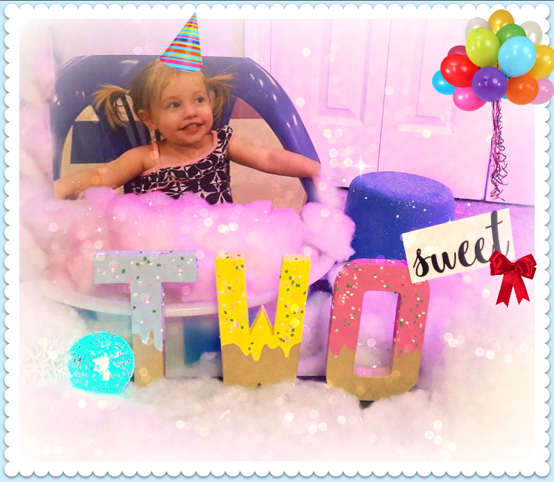 A little girl wearing a party hat is sitting in a bathtub with a sign that says sweet