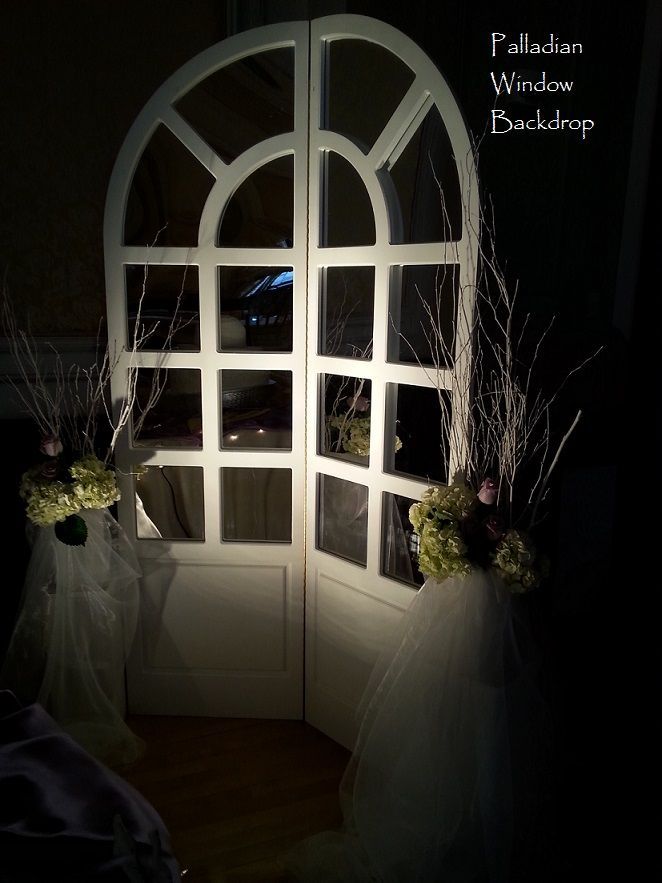 A white door with flowers in front of it that says palladian window backdrop